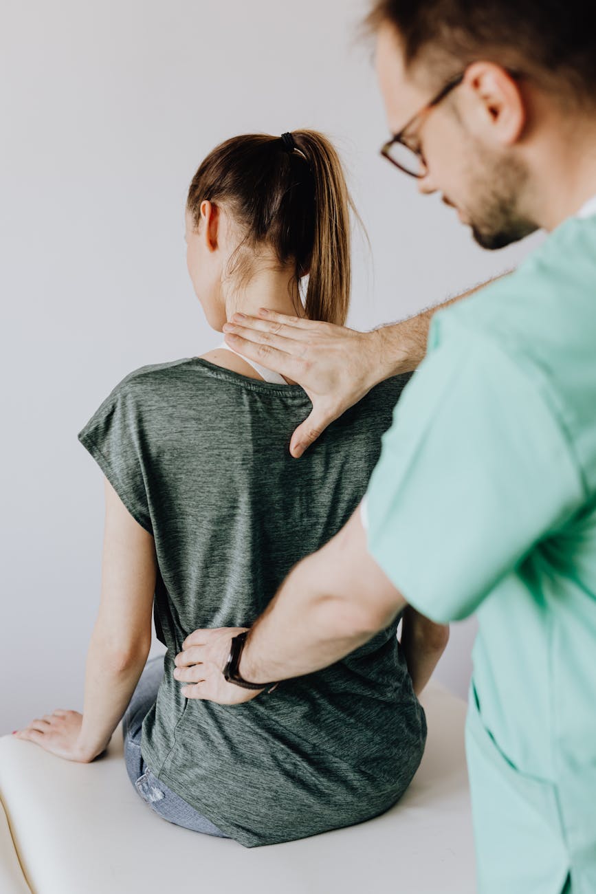 Chiropractor performing spinal adjustment on patient in bright treatment room